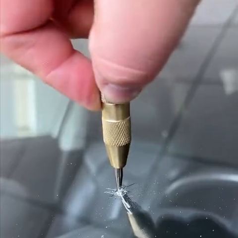 A probe picking loose glass out of the impact point of a chip