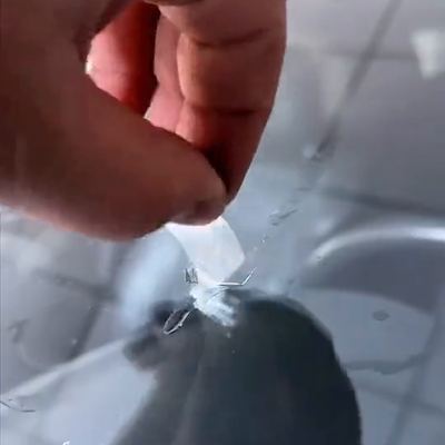 Scraping the cured resin flat at the end of a repair